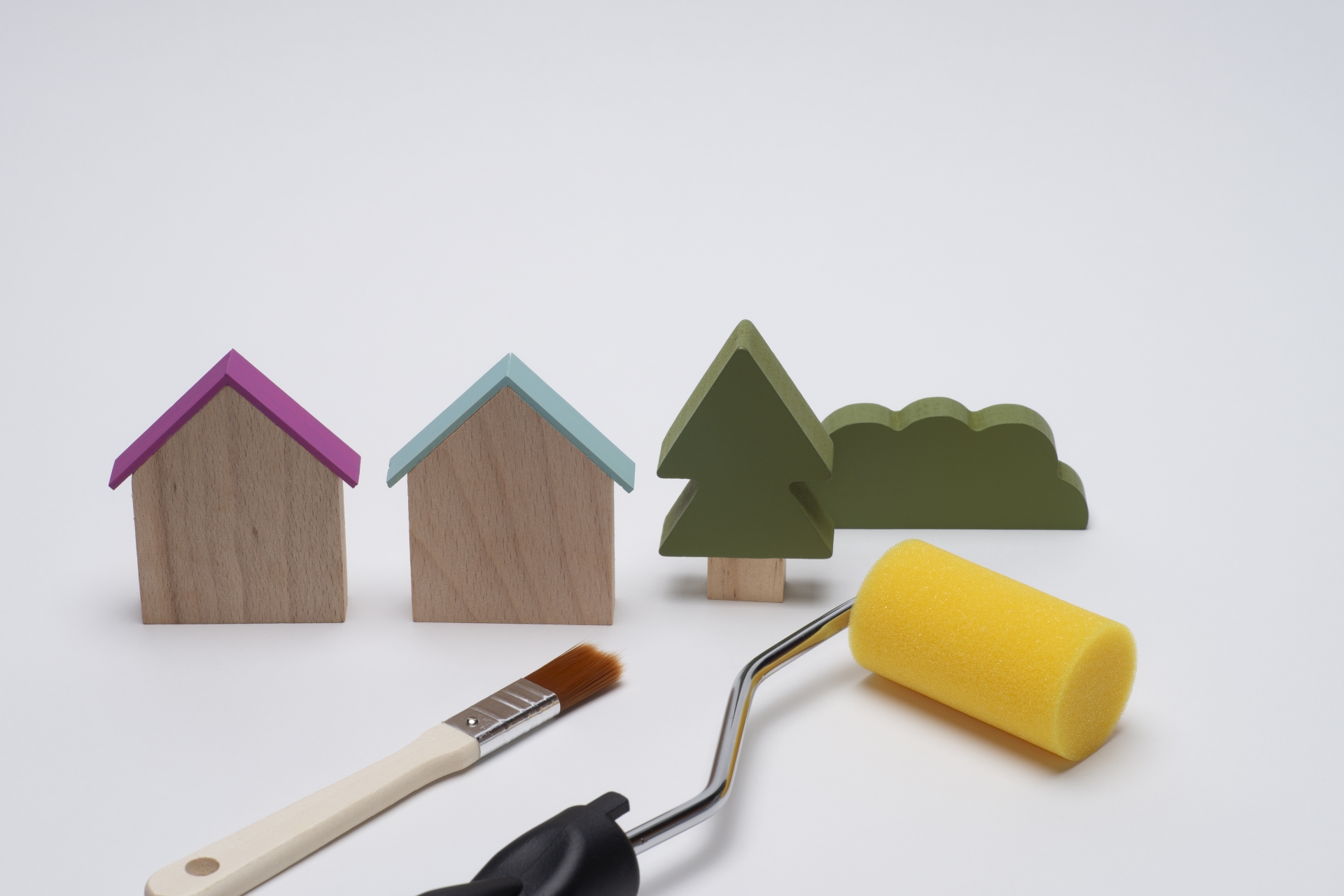 アパート外壁塗装の費用計画をイメージした住宅模型とローラー