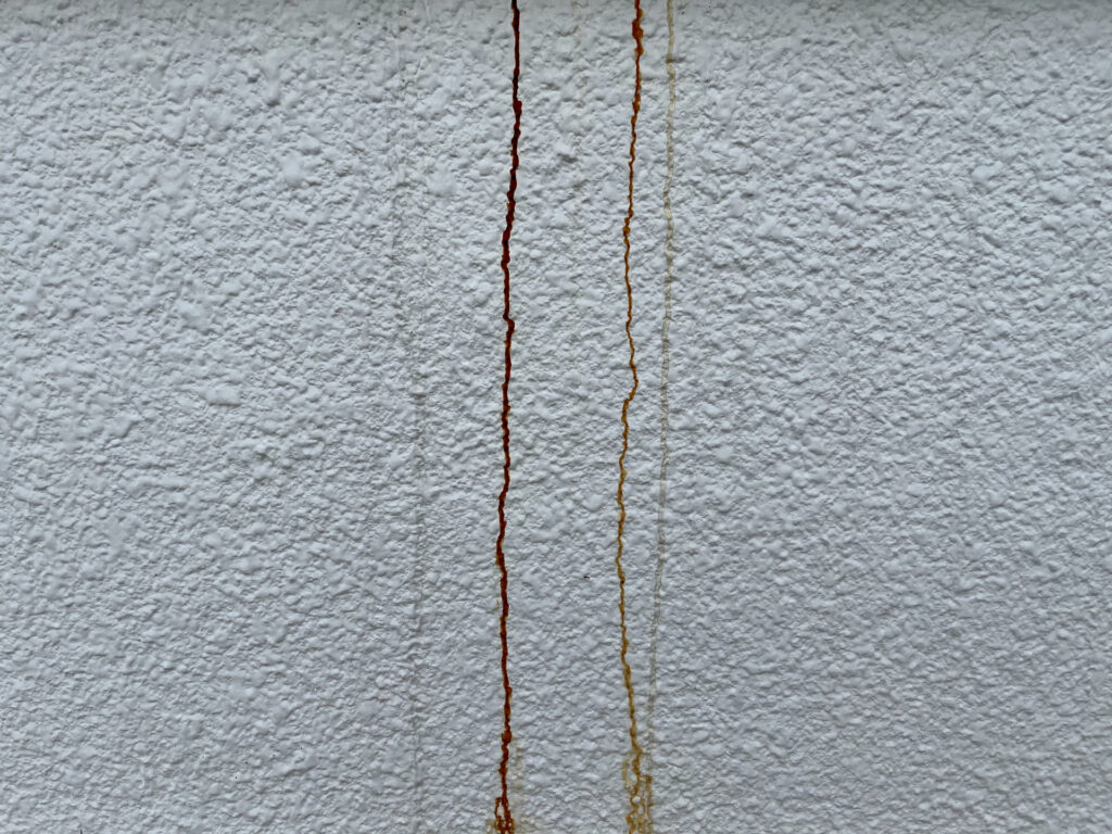 外壁コンクリートに発生した縦方向のひび割れと補修跡